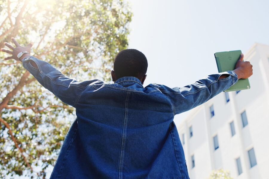 Happy student holding his hands up